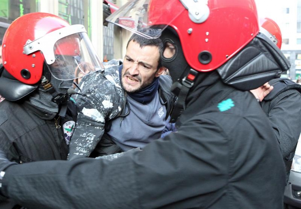 Un piquetero forcejea con agentes de la Ertzaintza en las cercanías de El Corte Ingles de Bilbao. Foto: EFE