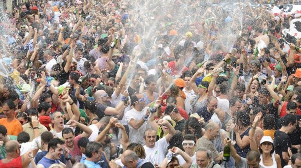 La multitud descorcha botellas de champán durante la bajada de Celedón. EFE