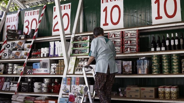 Una mujer coloca sobre unas estanterías los productos. Foto: EFE