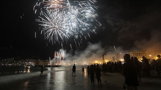Varias personas disfrutan de los fuegos articiales de San Sebastián. Imagen de archivo: EFE