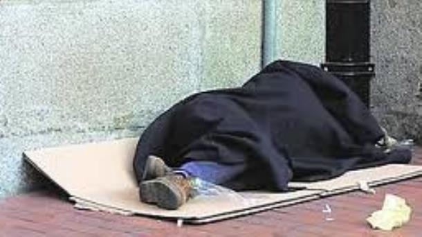 Una persona sin hogar durmiendo en la calle.