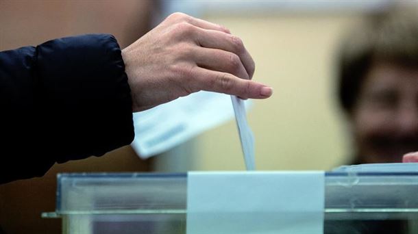 Una persona introduciendo un voto en una urna