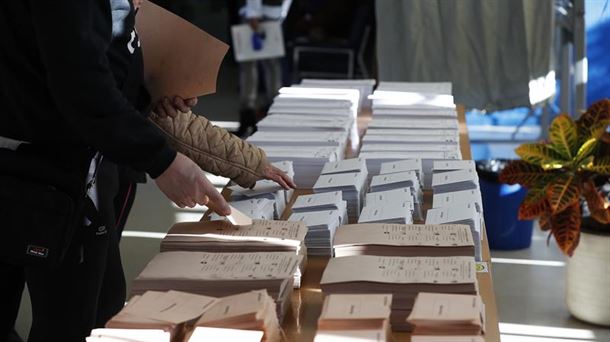 Varias personas escogiendo papeleta para las elecciones generales