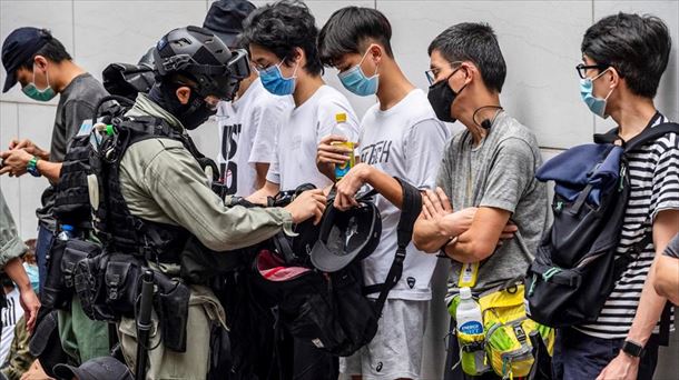 Un policía identifica a varios manifestantes contrarios a la ley en Hong Kong