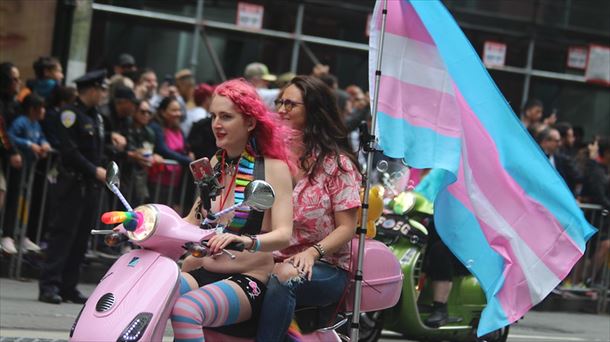 Bi emakume, transexualitatearen banderarekin