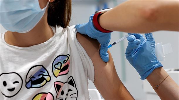 Personal sanitario vacunando a una joven