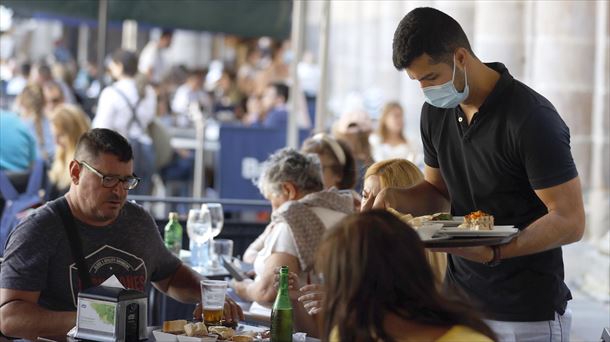 Un camarero sirve a los clientes en la terraza de un bar. EFE