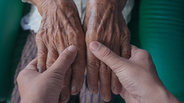 Un joven sostiene las manos a una persona mayor. CC-BY freepik