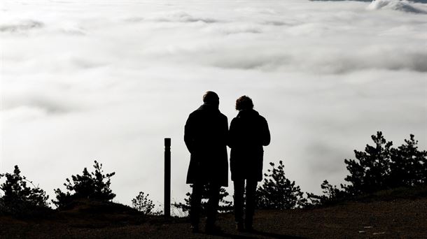 Dos personas, en el Alto de San Cristobal entre nieblas. 