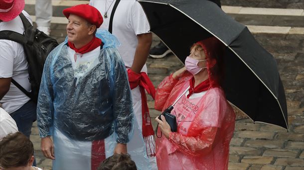 Una mujer espera al chupinazo con un paraguas. Foto: EFE.