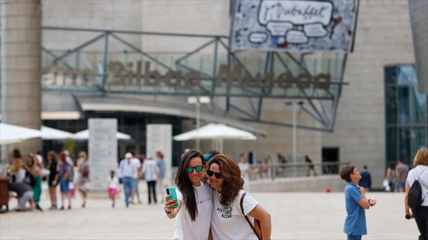 Dos turistas se fotografían en Bilbao, este verano. 