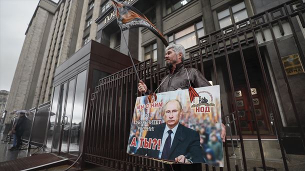 Un hombre sostiene una pancarta frente al edificio de la Duma Estatal Rusa en Moscú.